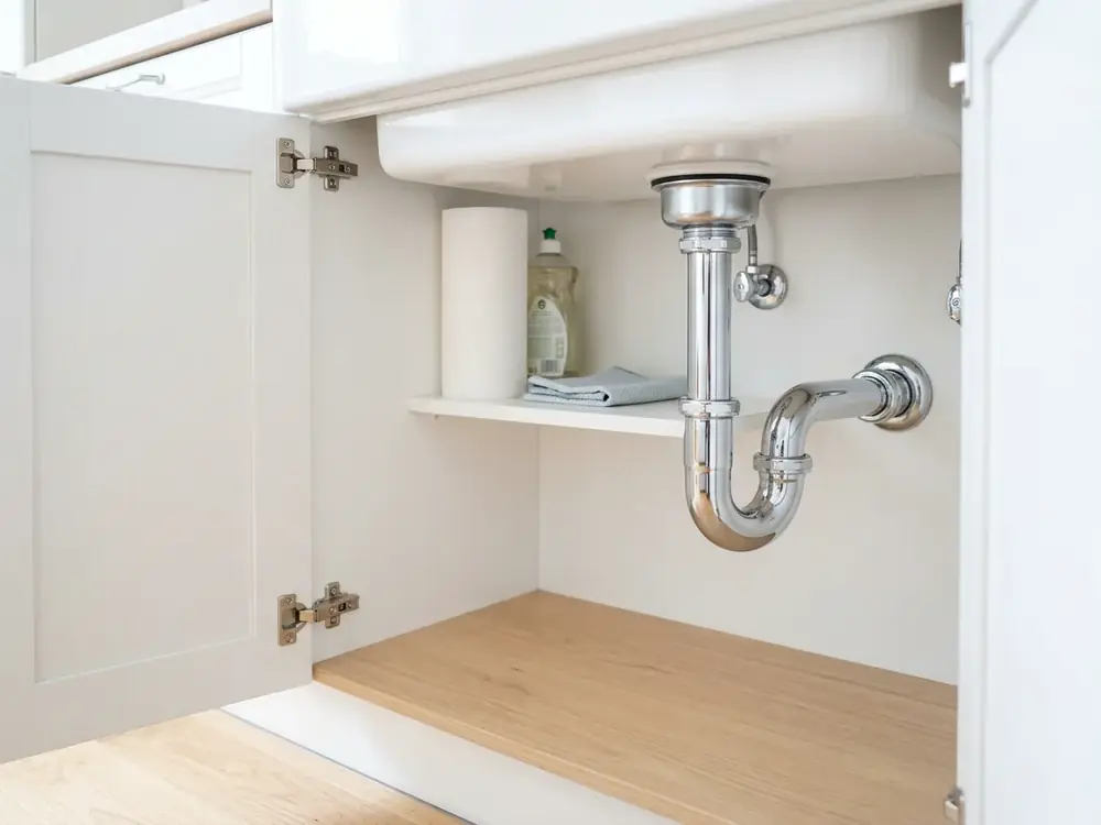Neuer verchromter Siphon in trockenem Unterschrank